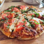 Close-up of a fresh Margherita pizza with tomatoes and basil. Perfect for Italian cuisine promotions.
